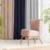 A pink accent chair is placed in front of three different colored curtains (pink, navy blue, and light gray) next to a window with a plant. Náhled obrázku produktu