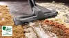 A vacuum cleaner head is shown cleaning up debris from a floor, with a graphic indicating high suction power. Voir les images du produit