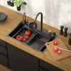 A modern kitchen sink with a faucet and tomatoes being washed. Produktbild-Vorschau