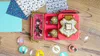 A Harry Potter themed badge-making kit is laid out on a wooden surface with decorative papers and various character badges. Anteprima dell’immagine prodotto