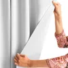 A person is holding open a white curtain. Produktbild-Vorschau