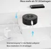 A power bank and a small circular device are connected by cables to white power adapters, illustrating a charging setup. Produktbild-Vorschau