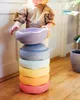 A child is interacting with a stack of colorful balancing stones. Anteprima dell’immagine prodotto