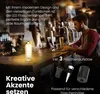 A man is working on a laptop at a bar counter, with a bottle lamp and beer glasses on the counter. Anteprima dell’immagine prodotto