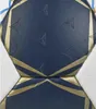 A close-up view of a dark blue handball with gold accents and embossed star-like patterns. Produktbild-Vorschau