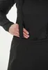 A close-up shot of a person's torso wearing a black garment, possibly overalls or a jumpsuit, with suspenders. Produktbild-Vorschau