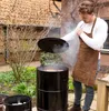 A man is grilling outdoors with a smoker. Produktbild-Vorschau