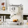 A cream-colored espresso machine is shown on a white countertop, with coffee brewing into a small glass beaker. Náhled obrázku produktu