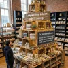 A man looks at a display of products in wooden crates in a store. Anteprima dell’immagine prodotto