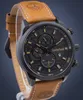 A Timberland men's watch with a black dial and a brown leather strap, shown against a dark blue background. Náhled obrázku produktu