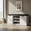 A shoe cabinet with a bench seat in a hallway or entryway, next to a window with a basket of blankets. Náhľad obrázku produktu