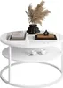 A modern round coffee table with two tiers, decorated with books, a vase with dried flowers, and decorative objects. Náhľad obrázku produktu