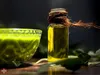 A bottle of neem oil and a bowl of green paste are displayed on a dark surface with some leaves. Náhled obrázku produktu