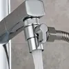 A close-up of a chrome shower diverter valve with water flowing out of it. Produktbild-Vorschau