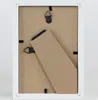 The back of a white picture frame with a brown backing board and a kickstand. Produktbild-Vorschau