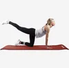 A woman is performing a yoga pose on a dark red yoga mat. Náhľad obrázku produktu