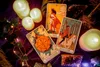 Tarot cards laid out with candles and crystals on a purple velvet cloth. Voir les images du produit