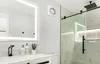 A modern bathroom with a vanity, mirror, and shower. Podgląd zdjęcia produktu