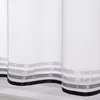 Close-up view of the bottom edge of white sheer curtains with horizontal stripes of gray and black satin ribbon. Produktbild-Vorschau