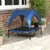 An elevated dog bed with a blue canopy sits on a patio next to a brick wall and potted plants. Anteprima dell’immagine prodotto