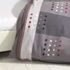 A close-up view of a grey, white, and red patterned duvet cover. Produktbild-Vorschau
