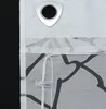 A close-up view of a white sheer curtain with a black abstract pattern and a silver grommet at the top. Produktbild-Vorschau