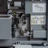 A close-up view of the internal threading mechanism of a sewing machine. Produktbild-Vorschau