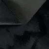A close-up view of the underside and fluffy surface of a black rug. Produktbild-Vorschau
