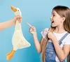 A young girl excitedly points at a plush goose held by an unseen person against a blue background. Anteprima dell’immagine prodotto
