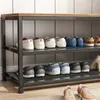 A shoe rack with shoes on multiple shelves, against a tiled wall. Podgląd zdjęcia produktu