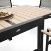 A close-up view of a wooden slatted table with a black frame, part of an outdoor dining set. Produktbild-Vorschau