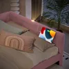 A pink daybed with pillows and a tablet charging on the headboard. Podgląd zdjęcia produktu