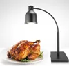A roasted chicken is presented on a white plate, garnished with rosemary, under a black heat lamp. Produktbild-Vorschau