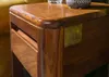 A close-up of a wooden side table with a brass logo plate. Anteprima dell’immagine prodotto