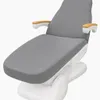 A gray dental or medical chair with wooden armrest accents on a white base, shown from a diagonal front view. Produktbild-Vorschau