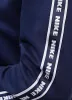 A close-up view of a dark blue garment with a white stripe featuring the Nike logo repeated along the sleeve. Produktbild-Vorschau