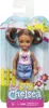 A Barbie Club Chelsea doll in its packaging, with a background depicting a sunny day with clouds, a fence, and flowers. Podgląd zdjęcia produktu