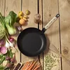 A frying pan surrounded by fresh vegetables and legumes on a wooden table. Podgląd zdjęcia produktu
