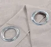 A close-up view of two metal grommets on a textured fabric, likely curtains. Produktbild-Vorschau