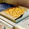 Shrimp being grilled on a griddle plate on a gas grill. Produktbild-Vorschau