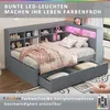 A grey bed with storage drawers and shelves, decorated with pink bedding and pillows, and illuminated by colorful LED lights. Produktbild-Vorschau