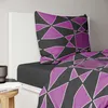 A close-up view of a bed with a pillow and duvet cover featuring a geometric pattern. Produktbild-Vorschau