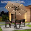 An outdoor patio scene at dusk with a table, chairs, and a lit umbrella. Produktbild-Vorschau