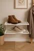A shoe rack with two pairs of shoes in a hallway. Produktbild-Vorschau