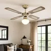 A ceiling fan with a light fixture is shown in a well-lit room with white paneled walls and a window with curtains. Náhľad obrázku produktu