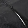 A close-up view of a black fabric with small dots and a zipper. Anteprima dell’immagine prodotto