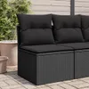 A close-up view of a black poly rattan garden sofa without armrests, featuring black cushions, placed on a paved patio with potted plants in the background. Podgląd zdjęcia produktu