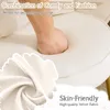 A hand pressing into a plush white cushion, with text overlays highlighting comfort and material. Podgląd zdjęcia produktu