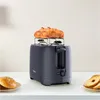 A dark gray toaster with two croissants on top, placed on a white countertop with bagels and sliced bread nearby. Produktbild-Vorschau