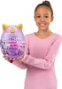 A young girl is holding a large, purple, egg-shaped toy with gold unicorn horns and ears. The toy has colorful graphics and text on it. Produktbild-Vorschau